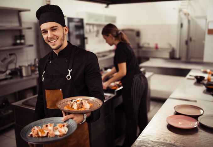 Un serveur sortant d'une cuisine avec des plats à la main